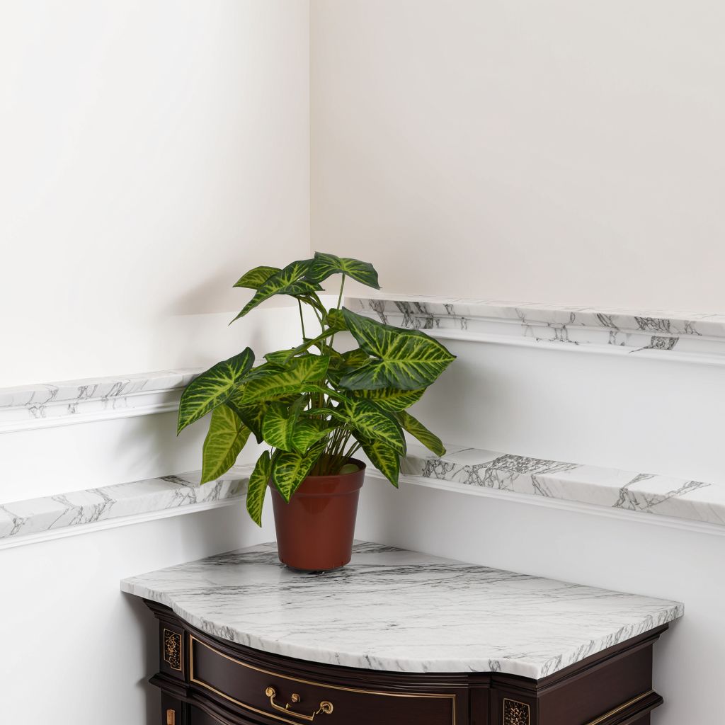 Artificial potted plant with green leaves in a modern interior setting.