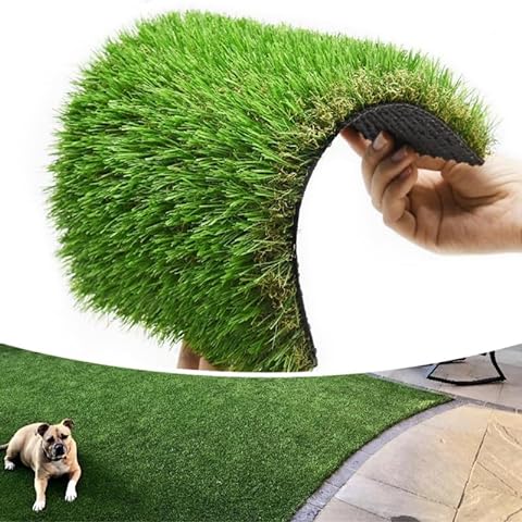 Hand holding a roll of artificial grass with a dog lying on a installed patch.