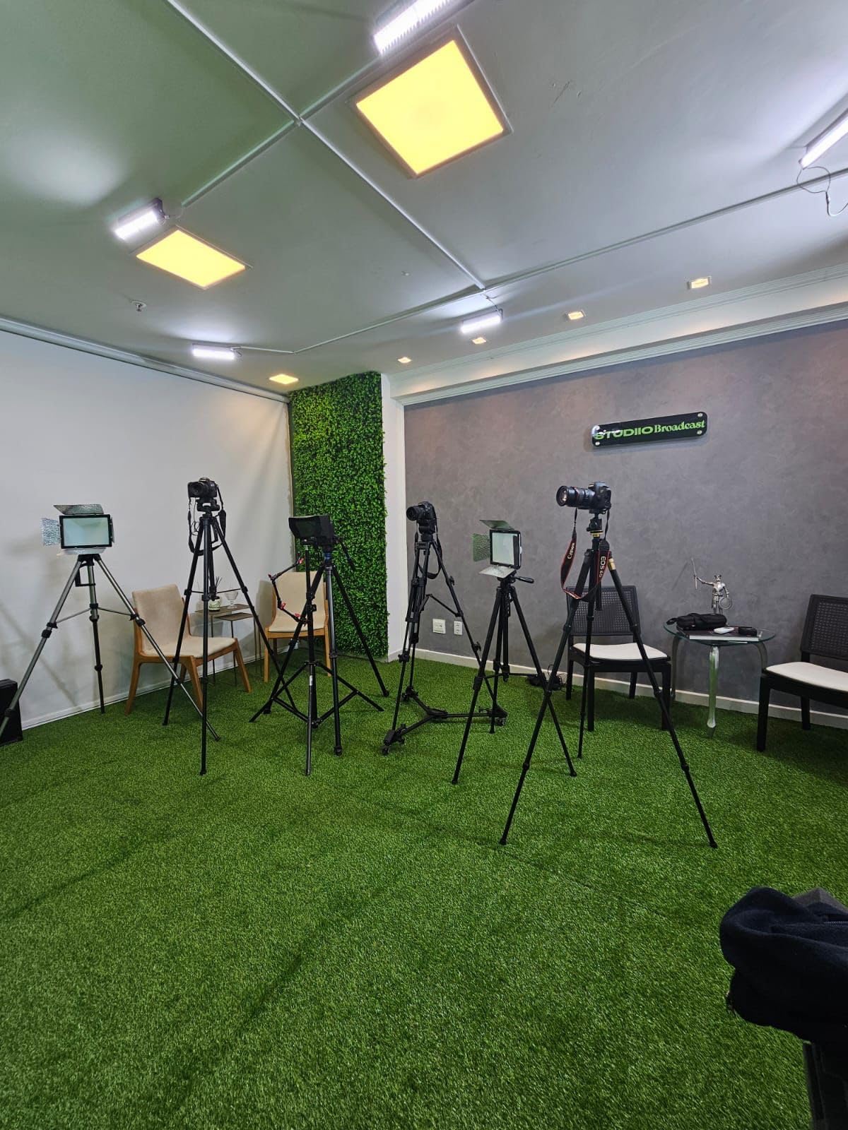 Room with multiple cameras on tripods set up for recording or broadcasting.