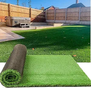 Roll of artificial grass on a green lawn with a wooden fence and shed in the background.