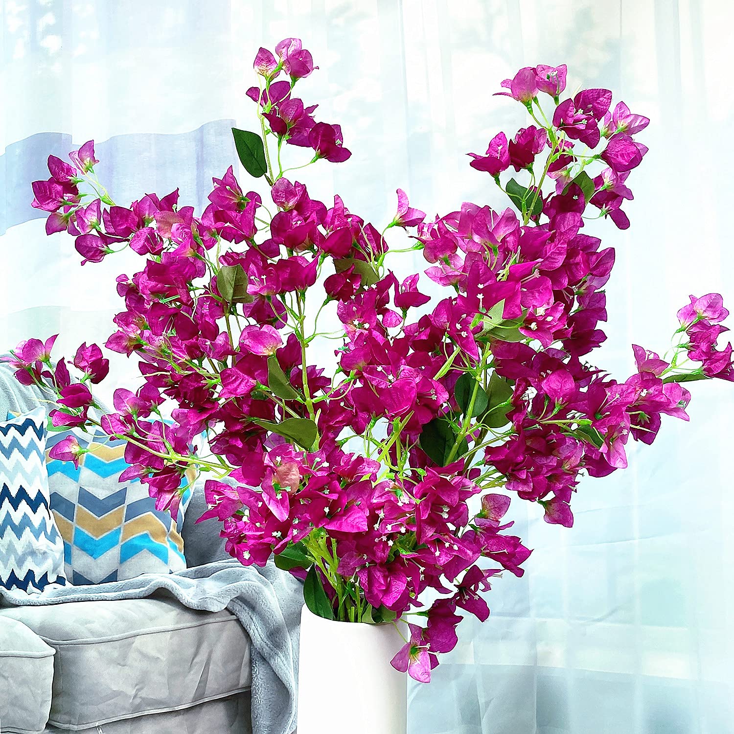Bouquet of pink flowers in a white vase on a light blue background