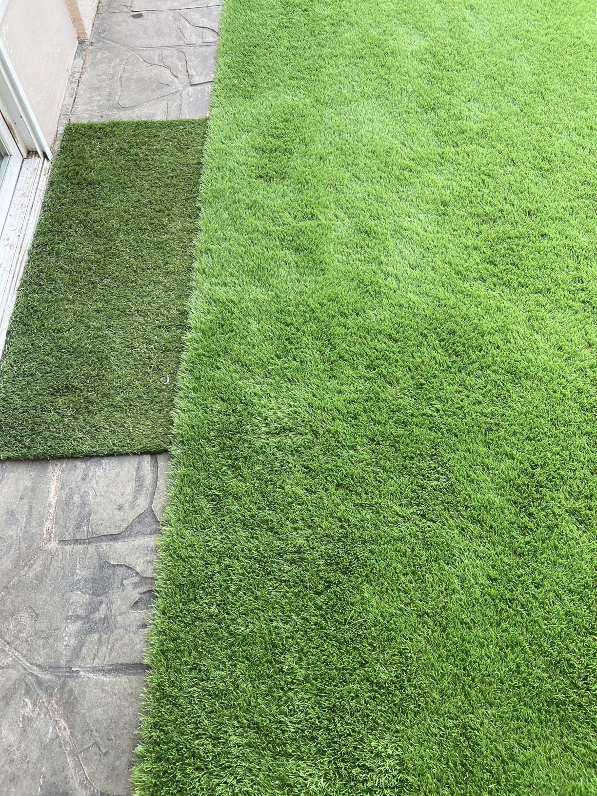 Artificial grass mat on a stone patio