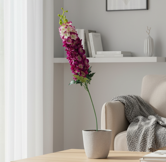 Modern living room with a wooden coffee table, potted plant, and framed artwork.