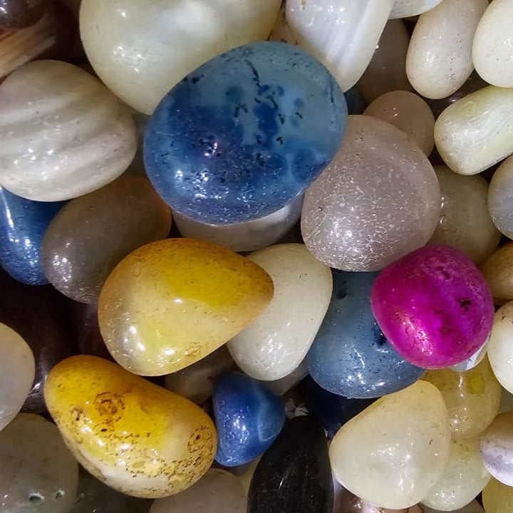Assorted multicolored pebbles on a white background