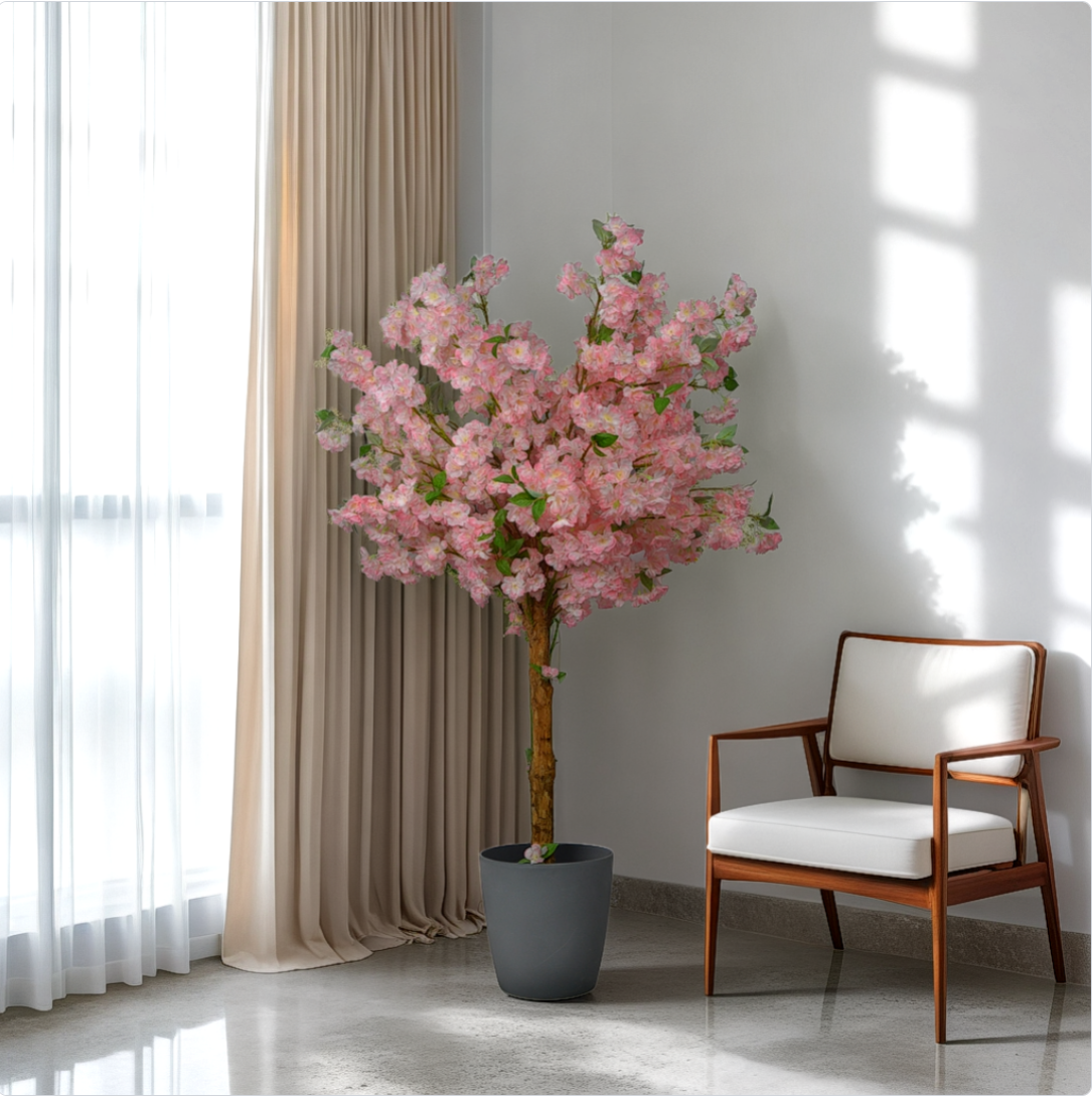 A 5 foot artificial cherry blossom tree with pink flowers, placed in a room corner next to a chair, without a pot.
