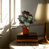 An artificial begonia bush in a red pot placed on a stack of books, next to a lamp, with a window in the background.