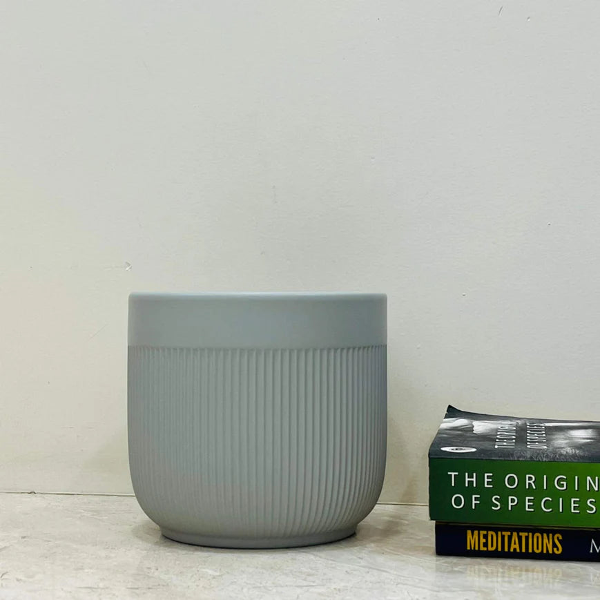 Gray textured planter next to a book titled &