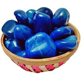 Blue stones in a woven basket on a white background