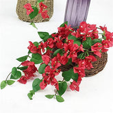 Artificial red bougainvillea flowers in a woven basket on a white background