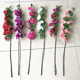 Set of artificial flower branches with pink, purple, and white flowers on a tiled floor.