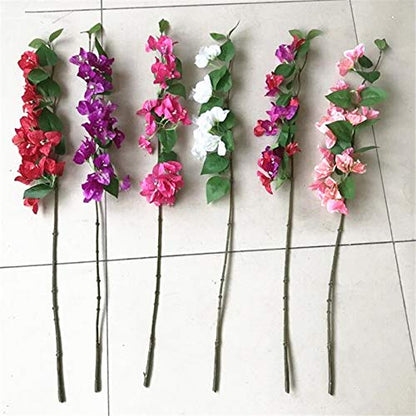 Set of artificial flower branches with pink, purple, and white flowers on a tiled floor.