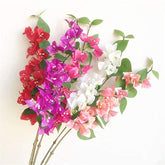 Artificial bougainvillea flowers in red, pink, and white on a white background