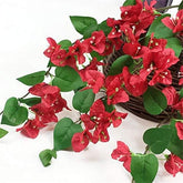 Artificial red bougainvillea flowers with green leaves on a white background