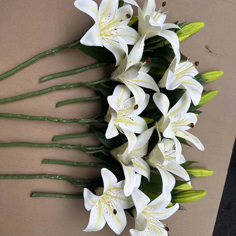 Bouquet of white lilies with green stems on a beige background