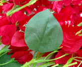 Close-up of red flowers with green leaves against a red floral background