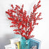 Red berry branches in a blue vase on a white background