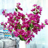 Bouquet of pink flowers in a white vase on a light blue background