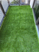 Artificial grass on a balcony with a metal railing.