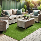 Outdoor patio set with wicker furniture and green rug on a wooden deck.