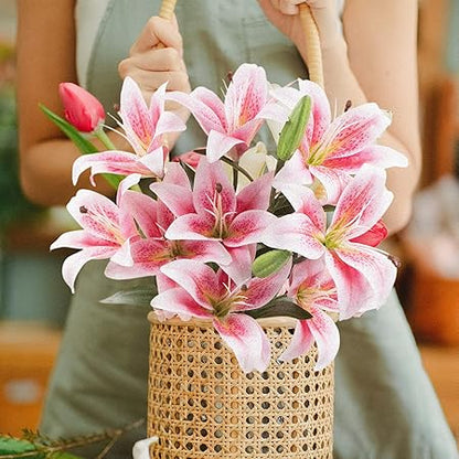 Bouquet of pink lilies in a woven basket held by a person.