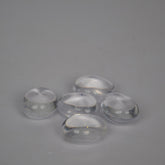 Five clear glass stones on a gray background