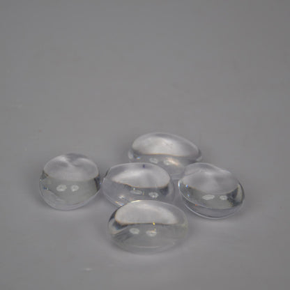 Five clear glass stones on a gray background