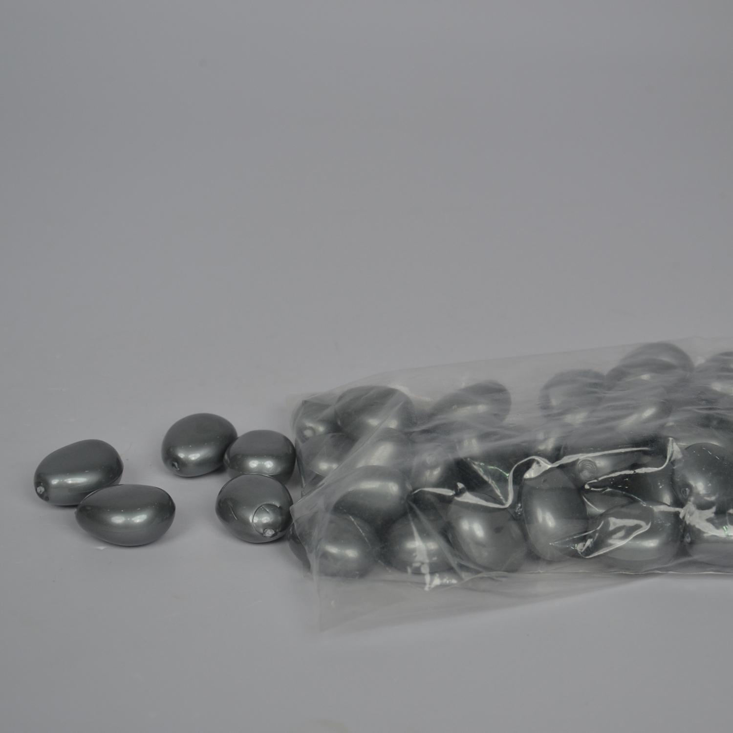 Gray metallic beads with a clear plastic bag on a gray background