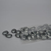 Gray metallic beads with a clear plastic bag on a gray background