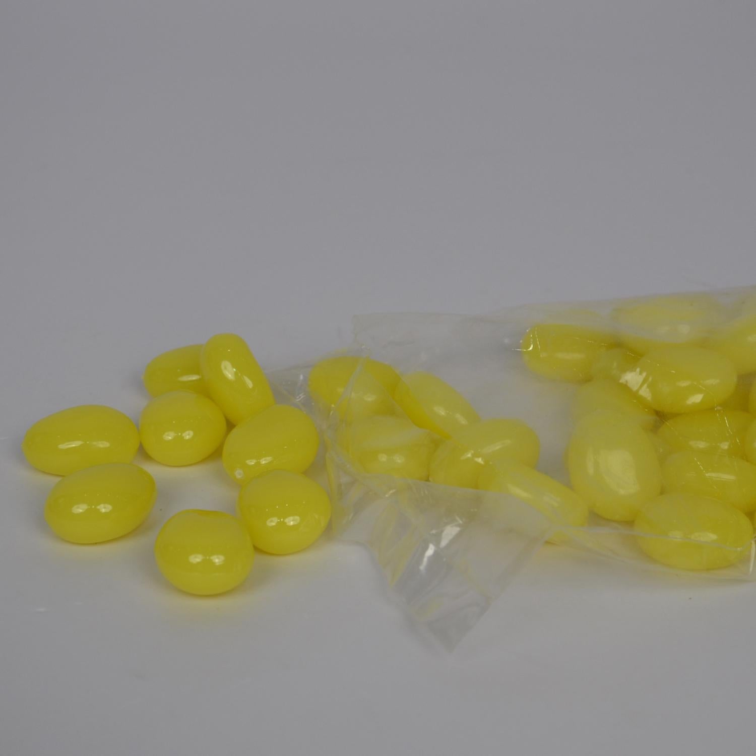Yellow pebbles in a clear plastic bag on a white background