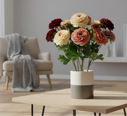 Floral arrangement in a vase on a table with a chair and blanket in the background