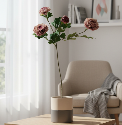 Floral arrangement in a pot on a table with a chair and window in the background