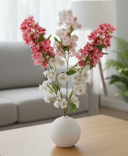 Floral arrangement in a white vase on a wooden coffee table with a blurred background