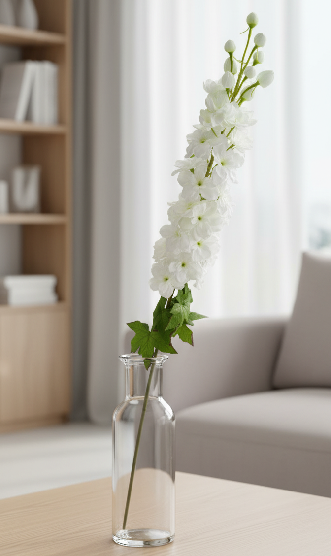Clear vase with white flowers on a wooden coffee table in a living room setting.