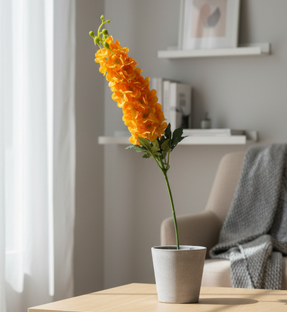 Orange flower arrangement in a concrete pot on a wooden table with a neutral background