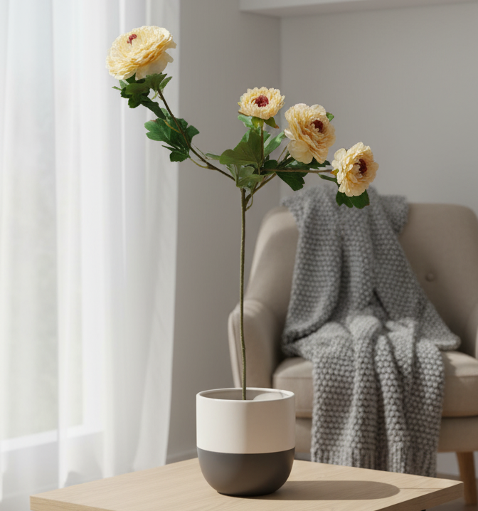 Floral arrangement in a pot on a table with a sofa and curtains in the background