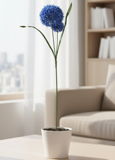 Blue flower in a pot on a coffee table with a beige sofa and bookshelf in the background