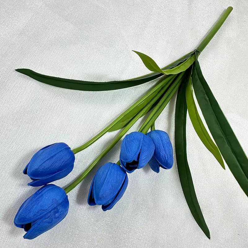 Bouquet of blue tulips with green leaves on a light gray background