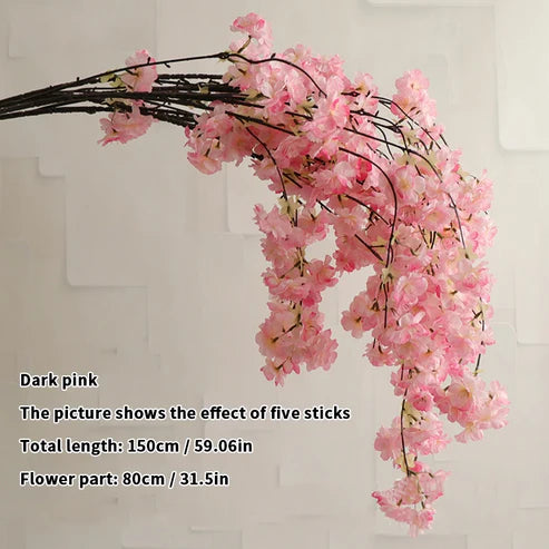 Dark pink artificial flower branch on a light gray background