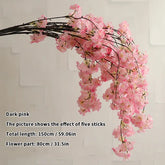 Dark pink artificial flower branch on a light gray background