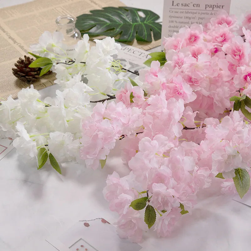 Artificial cherry blossom flowers in white and pink on a textured surface