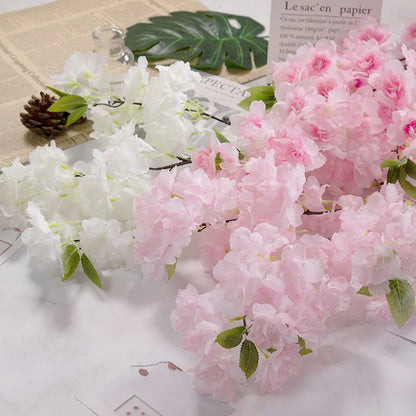Artificial cherry blossom flowers in white and pink on a textured surface