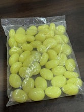 Bag of yellow pebbles on a wooden surface
