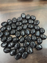 Black stones on a wooden surface