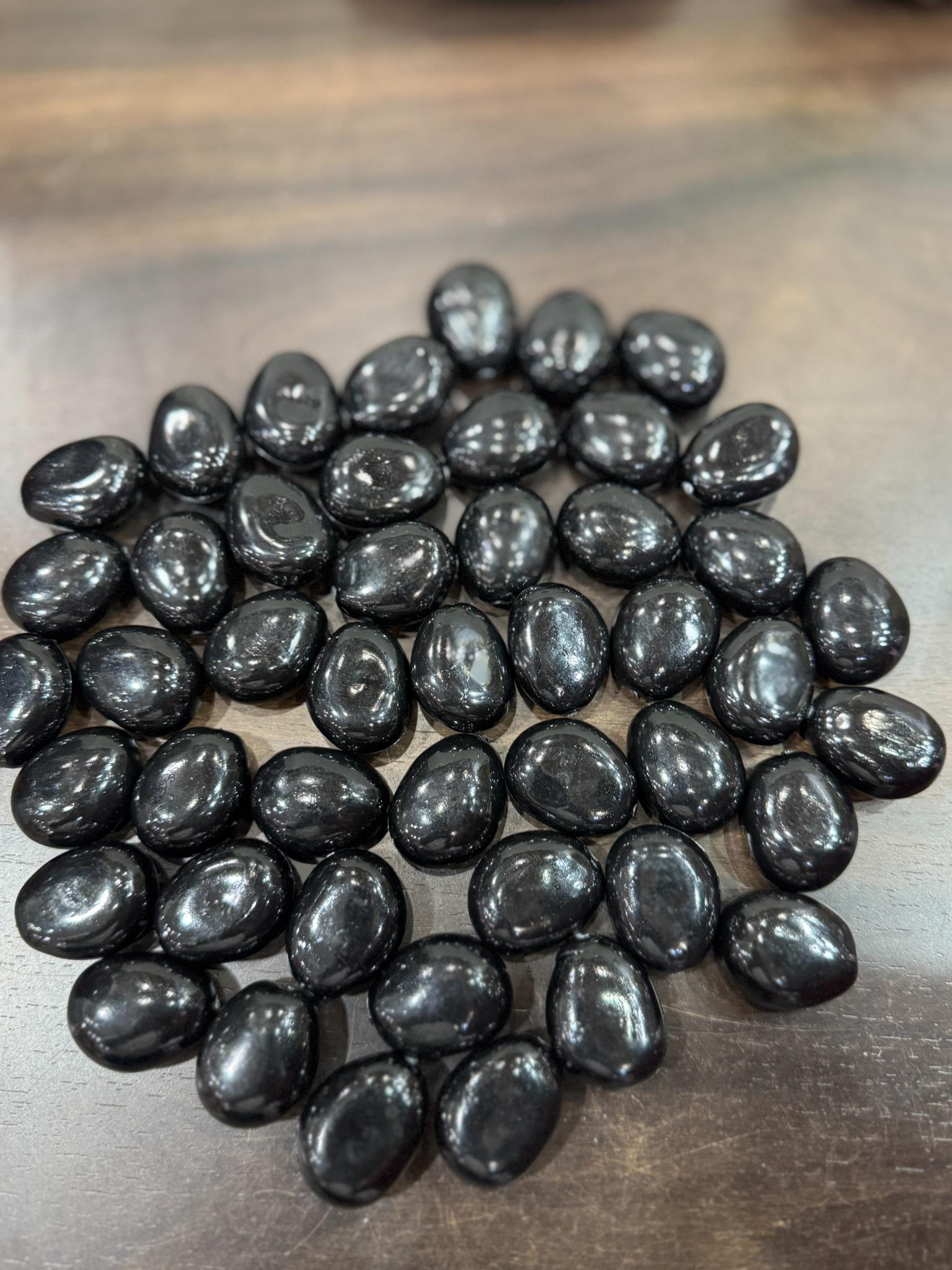 Black stones on a wooden surface