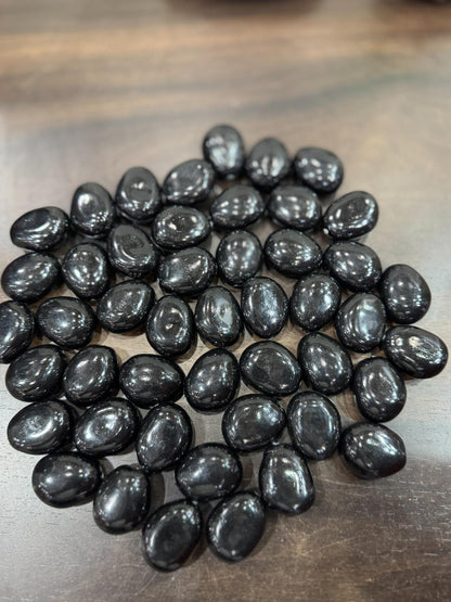 Black stones on a wooden surface