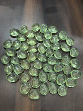 Green glass marbles on a dark wooden surface