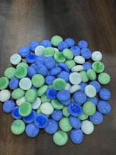 Blue and green marbles on a dark surface