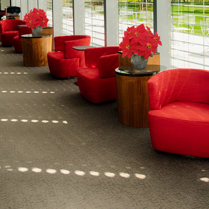 Modern interior with red chairs and wooden tables featuring potted plants.