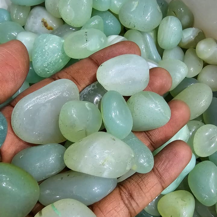 Hand holding a collection of light green stones