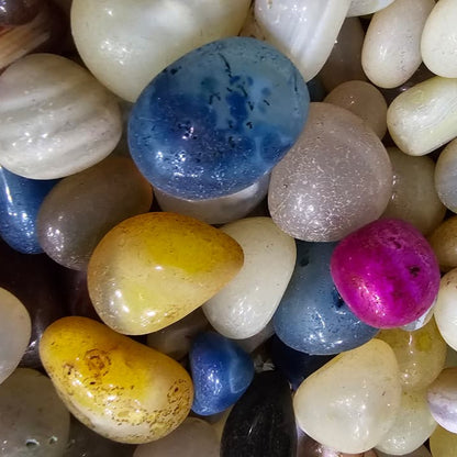 Assorted multicolored pebbles on a white background